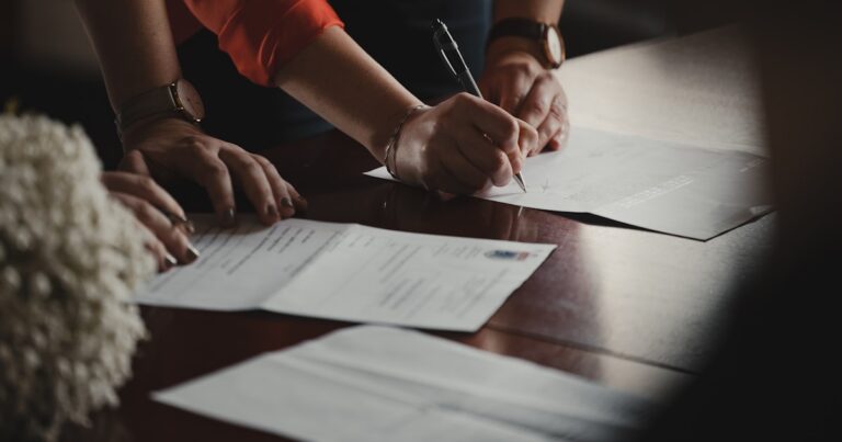 Advogado analisando e assinando documentos para processar o banco