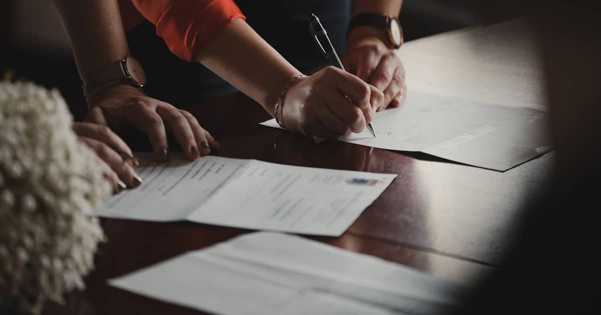 Advogado analisando e assinando documentos para processar o banco