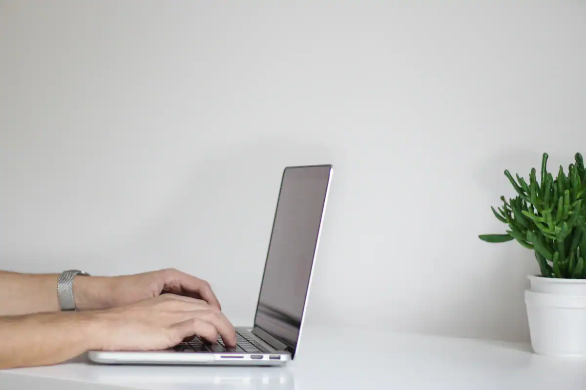 Mesa de trabalho com notebook e anotações, ilustrando a consulta online do boletim de ocorrência e a 2ª via