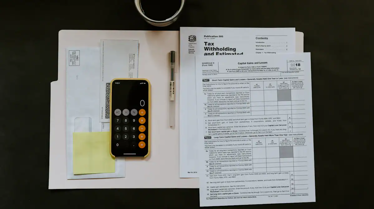 Calculadora e contas sobre a mesa, ilustrando o desconto mensal da RMC no benefício