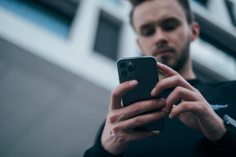 Início Pessoa olhando mensagem suspeita no celular, cena típica do golpe do WhatsApp clonado pedindo Pix