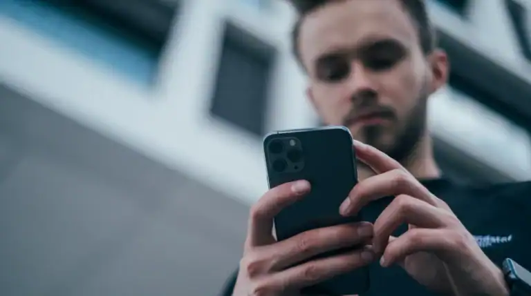 Início Pessoa olhando mensagem suspeita no celular, cena típica do golpe do WhatsApp clonado pedindo Pix